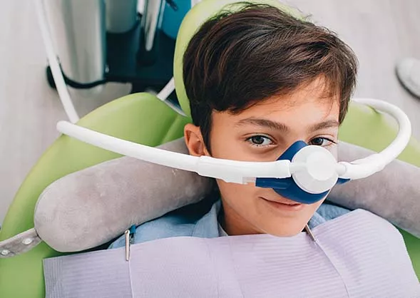 Little boy with device over his nose for sedation.